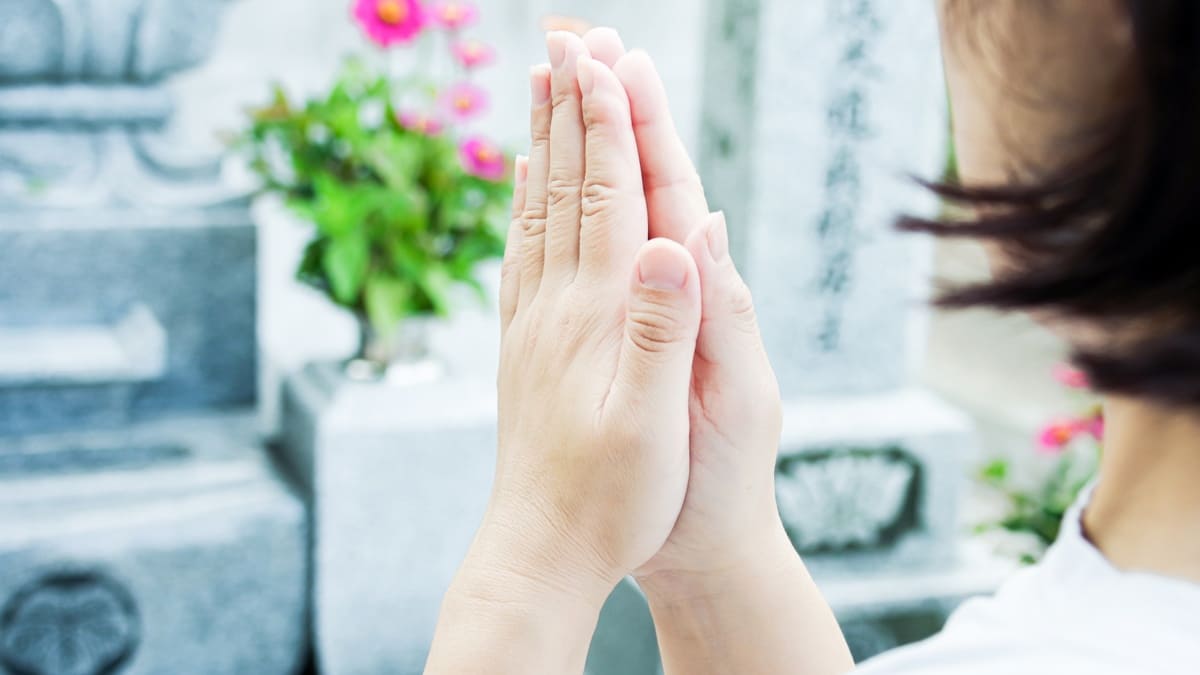 お墓の前で手を合わせる